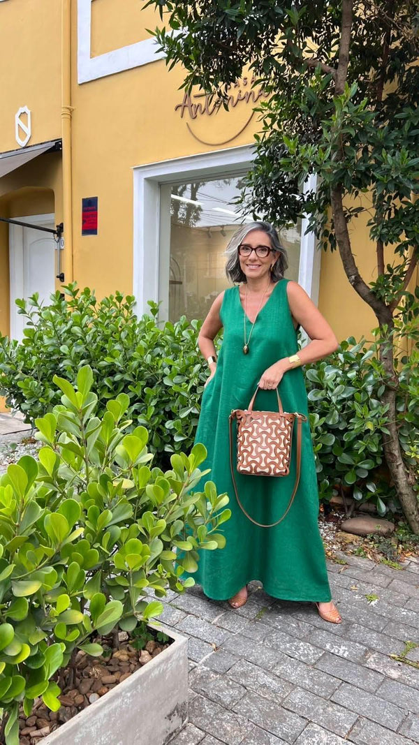 Mulher com vestido longo verde de linho, bolsa de mão, ao ar livre em frente a loja, moda feminina sofisticada EZILDINHA