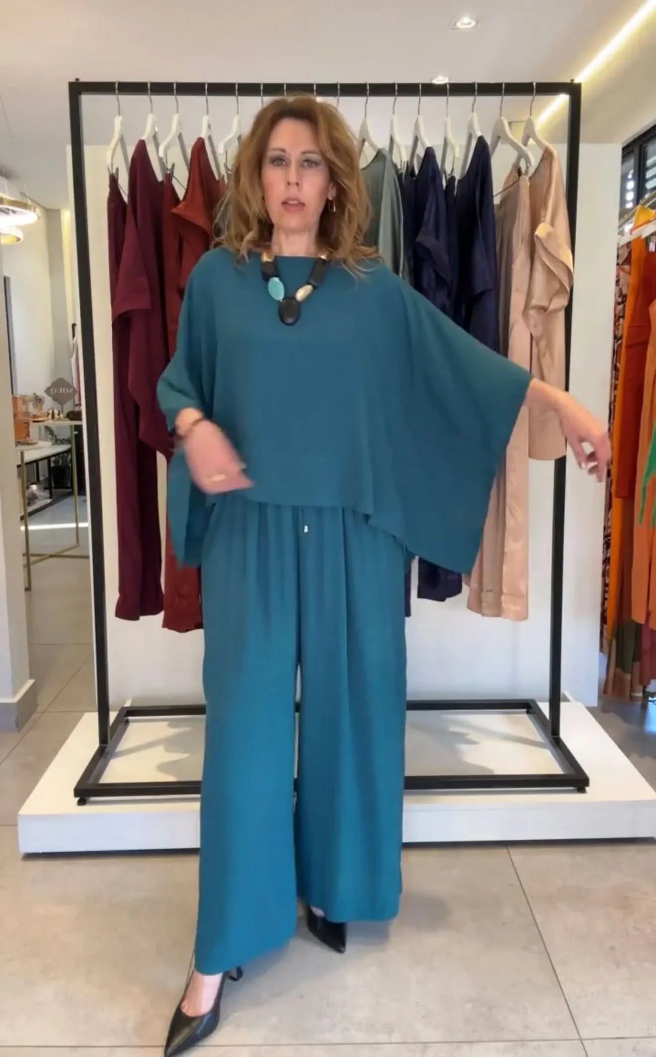 Mulher usando conjunto de viscose azul, com kimono manga larga e calça pantalona, em loja de moda feminina EZILDINHA