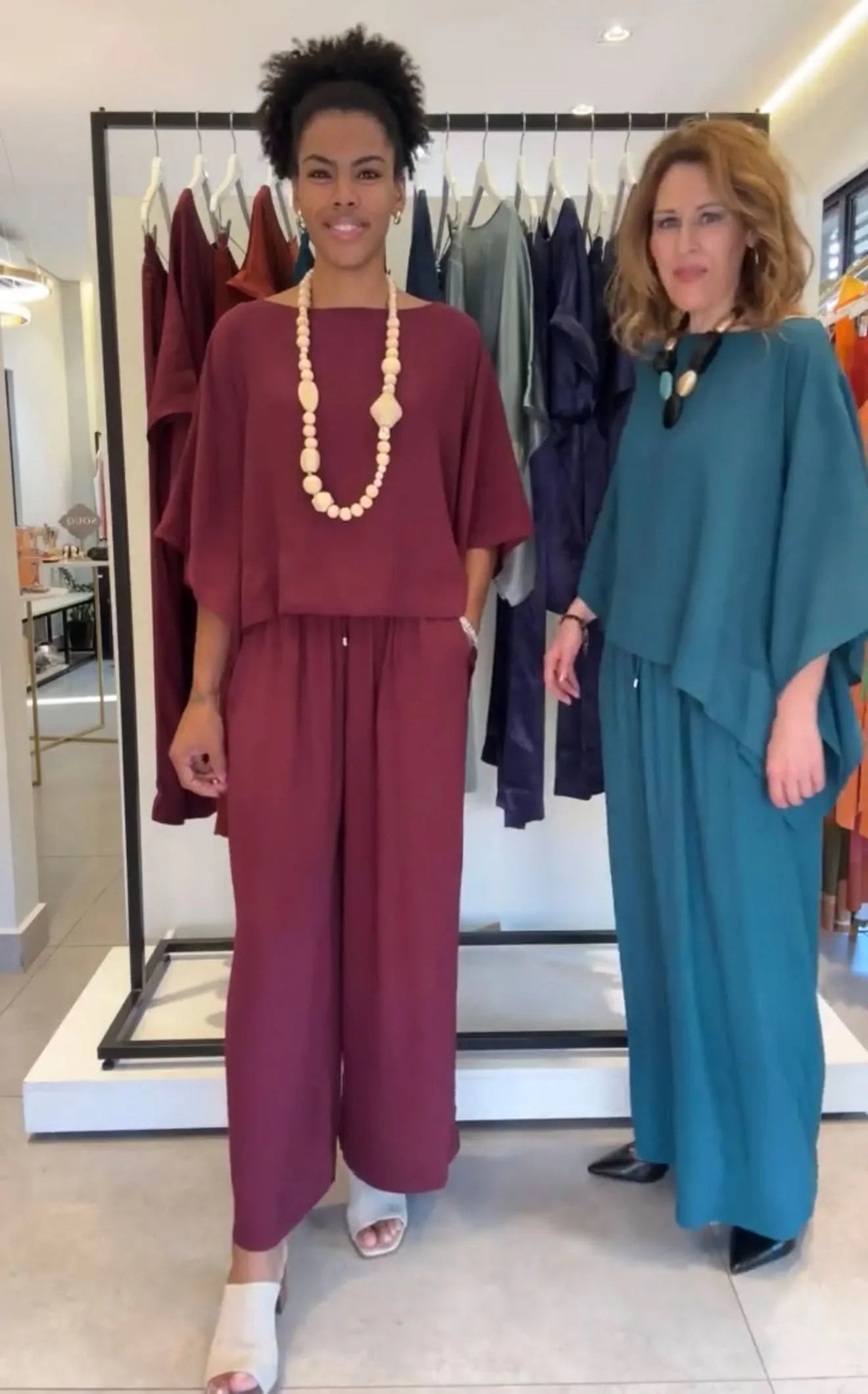 Duas mulheres vestindo conjuntos de kimono de viscose em vinho e azul, em loja de moda feminina EZILDINHA