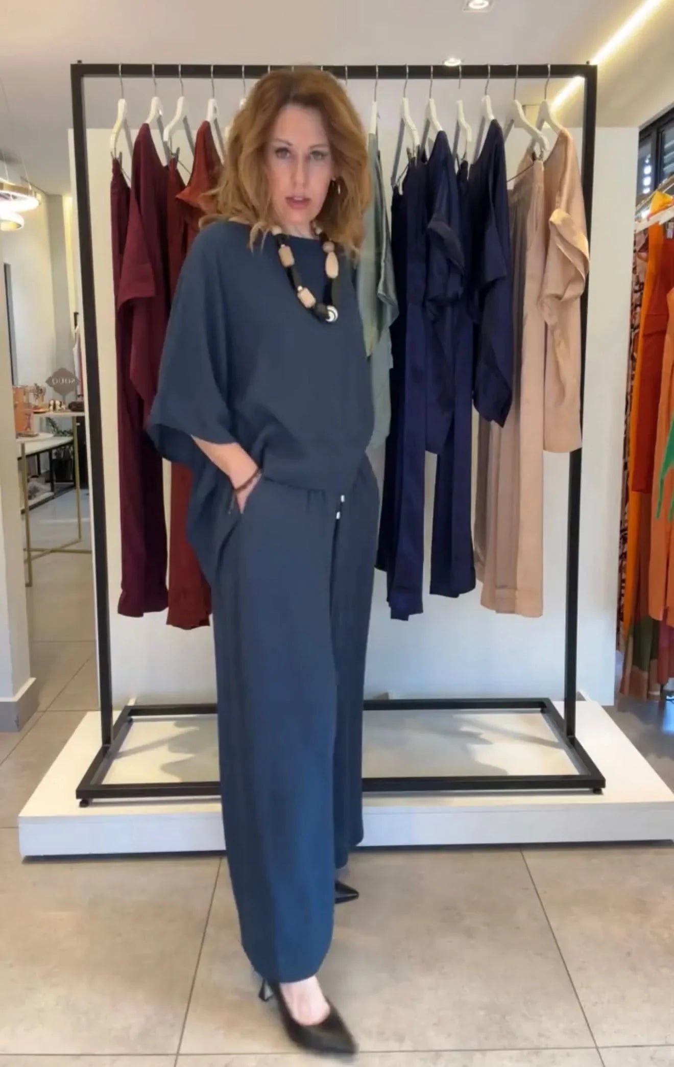 Mulher usando conjunto kimono de viscose azul, calça ampla e colar, em loja de moda feminina EZILDINHA