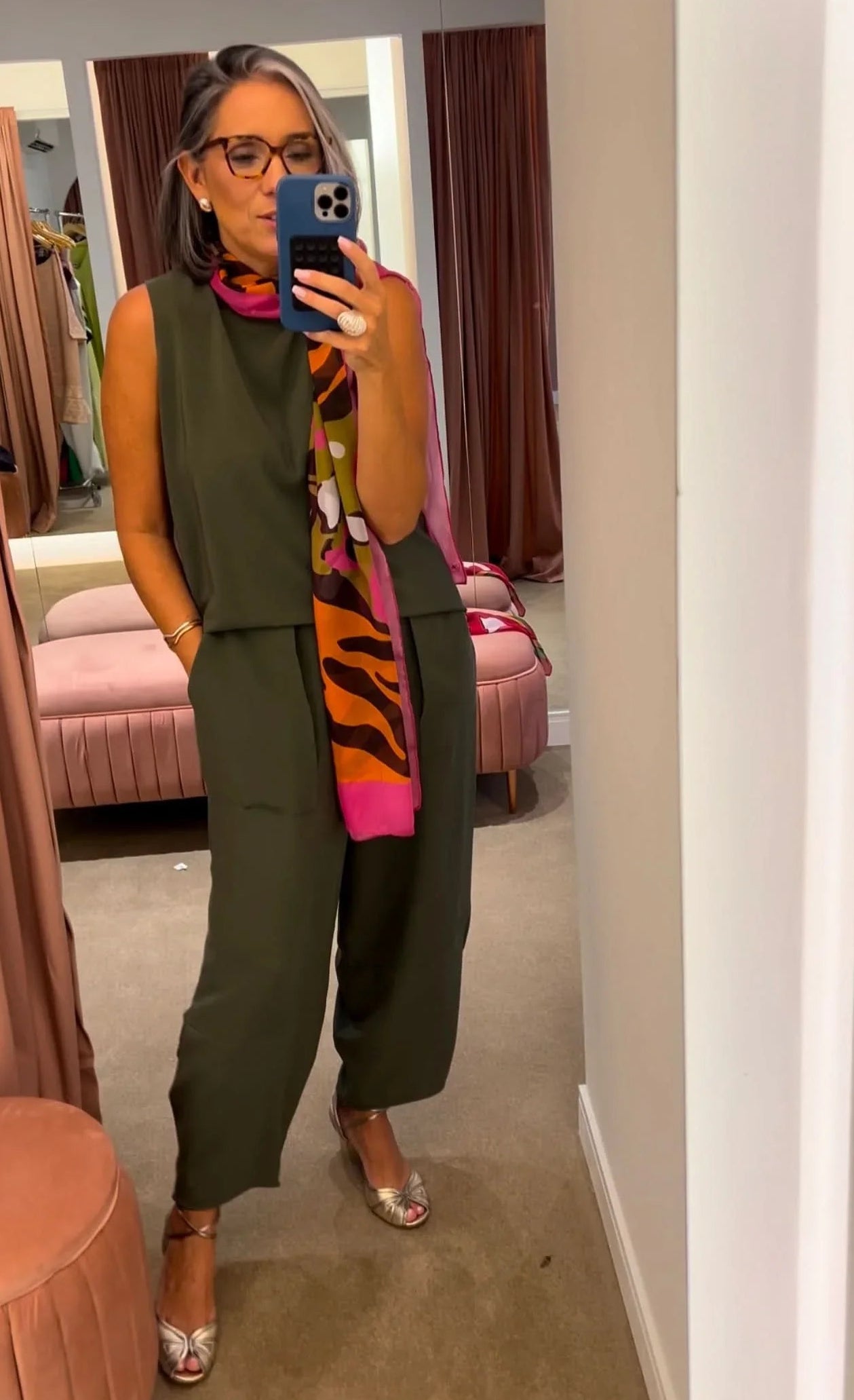 Mulher usando conjunto verde de seda pura com lenço estampado colorido, em provador elegante EZILDINHA