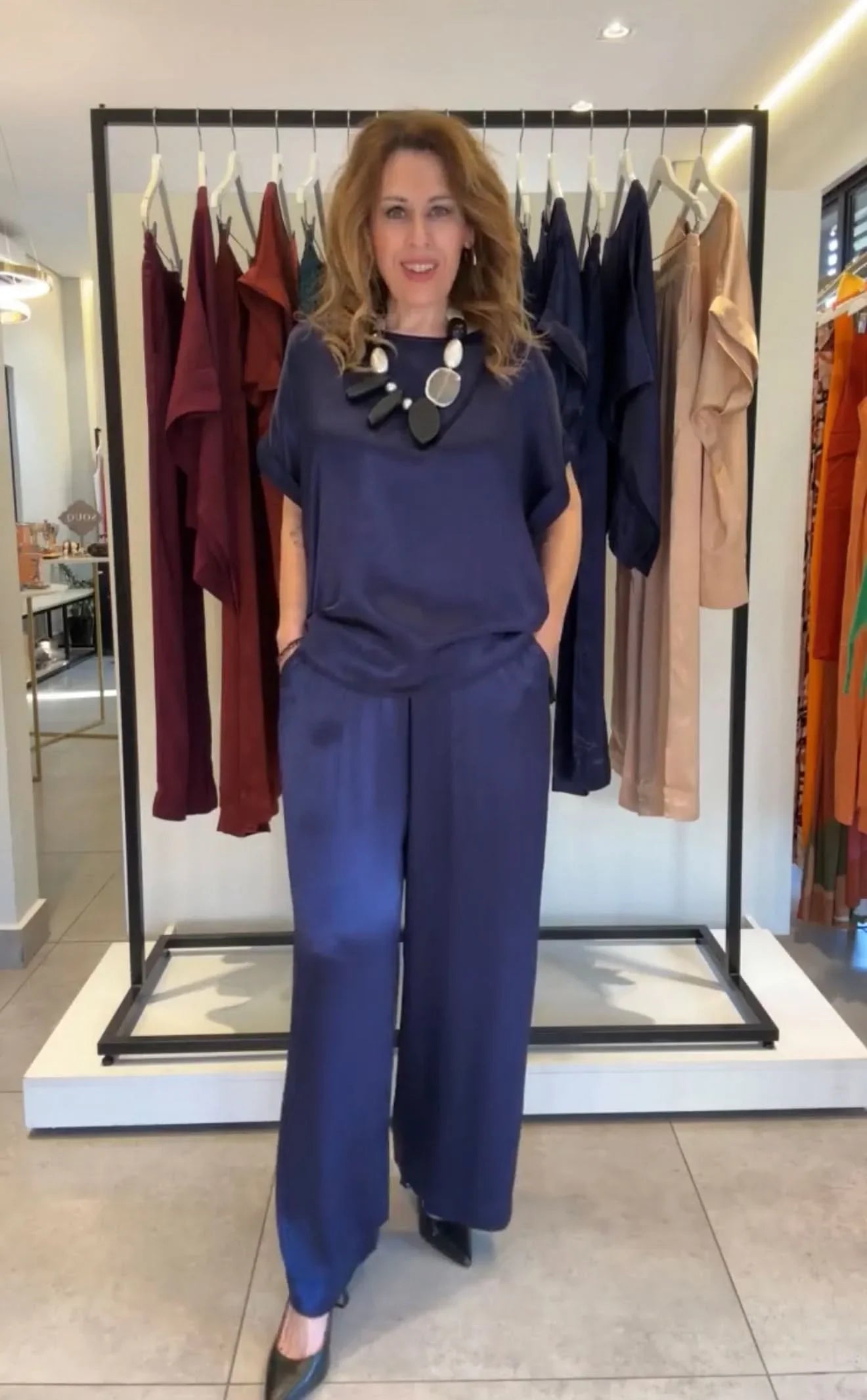 Mulher usando conjunto pantalona azul marinho com blusa de manga japonesa em loja de moda feminina EZILDINHA