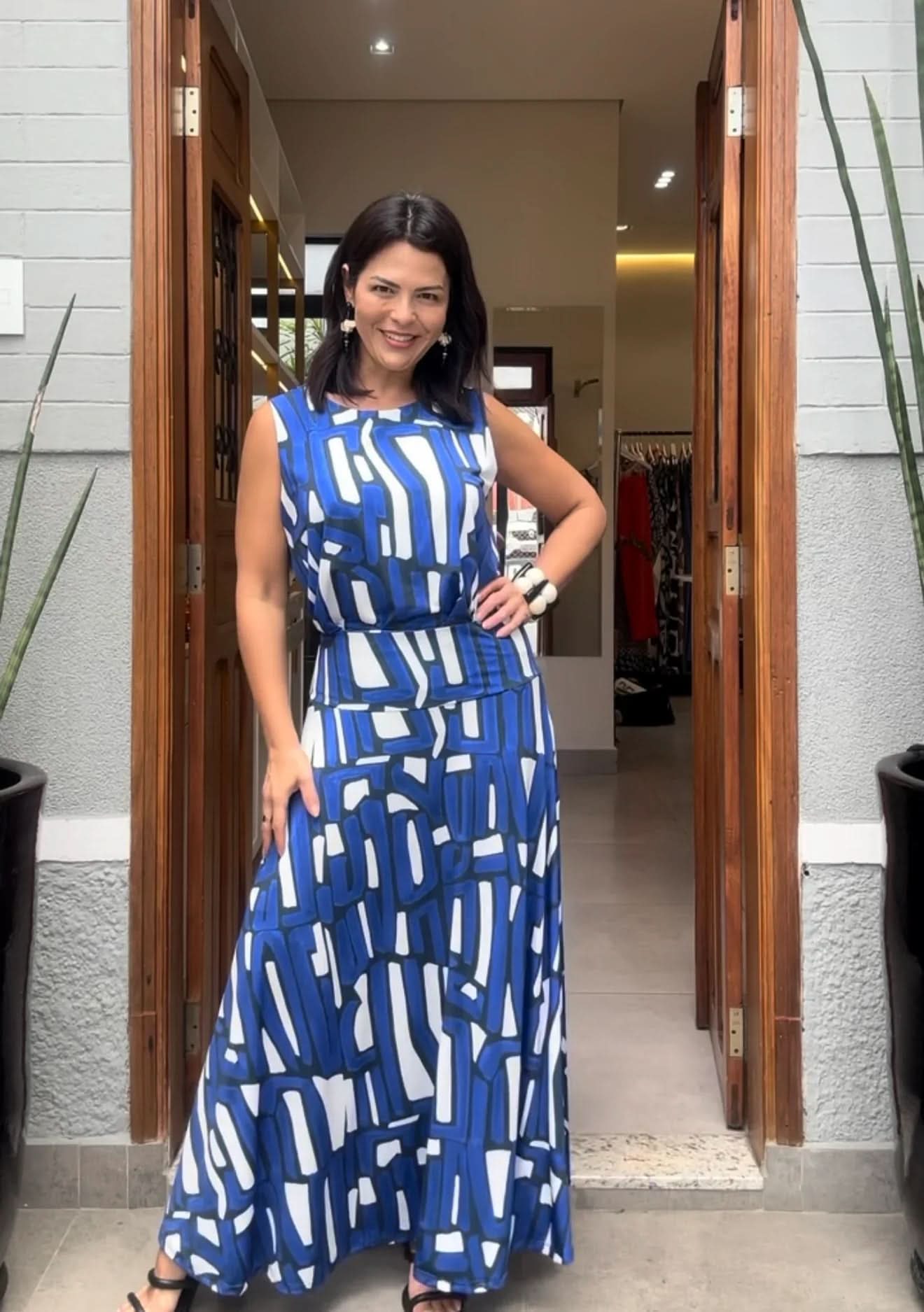 Mulher usando conjunto de saia longa com estampa geométrica azul e branca na entrada de loja EZILDINHA