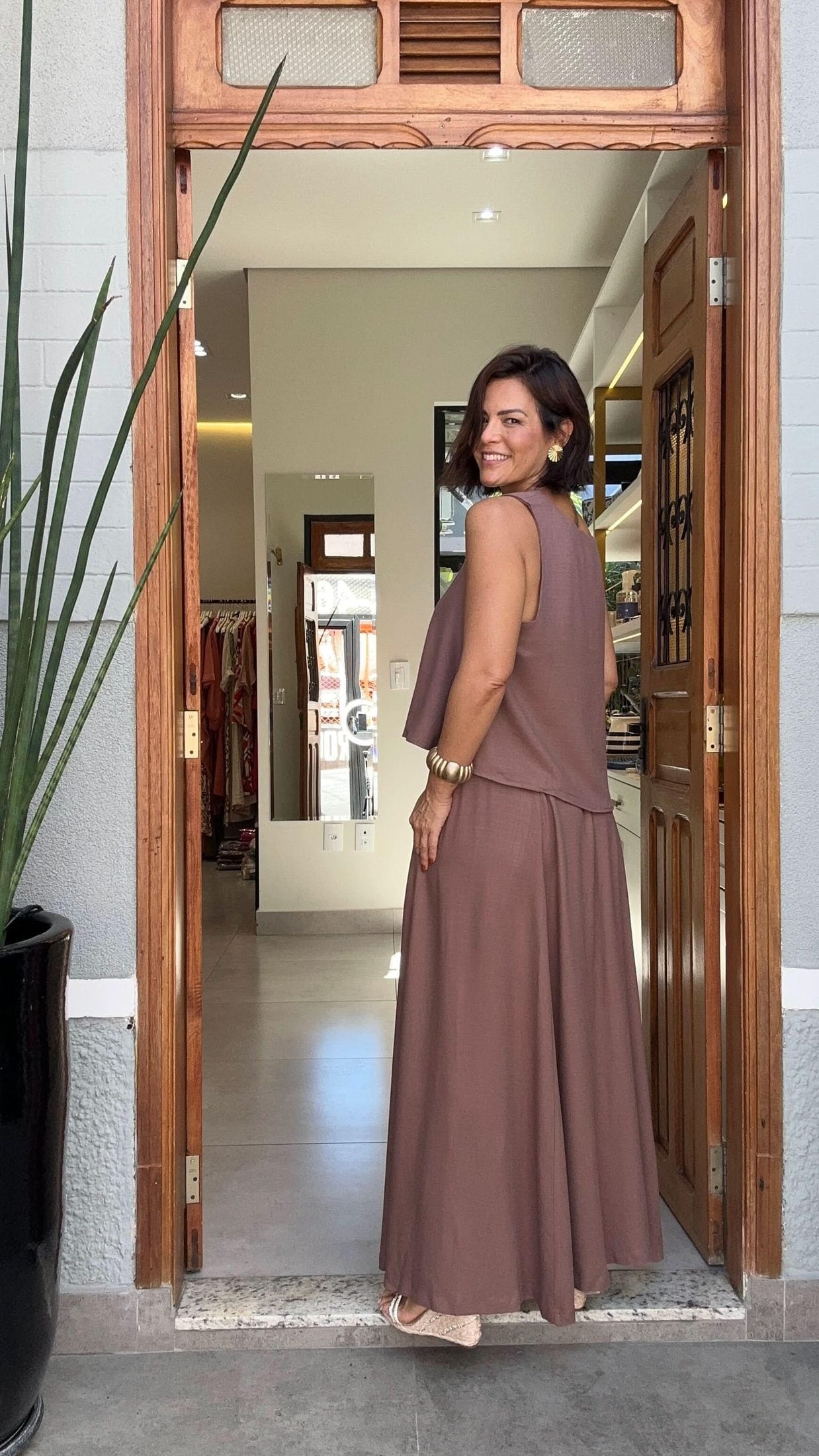 Mulher usando conjunto de saia longa e blusa de viscose marrom, em ambiente interno elegante EZILDINHA