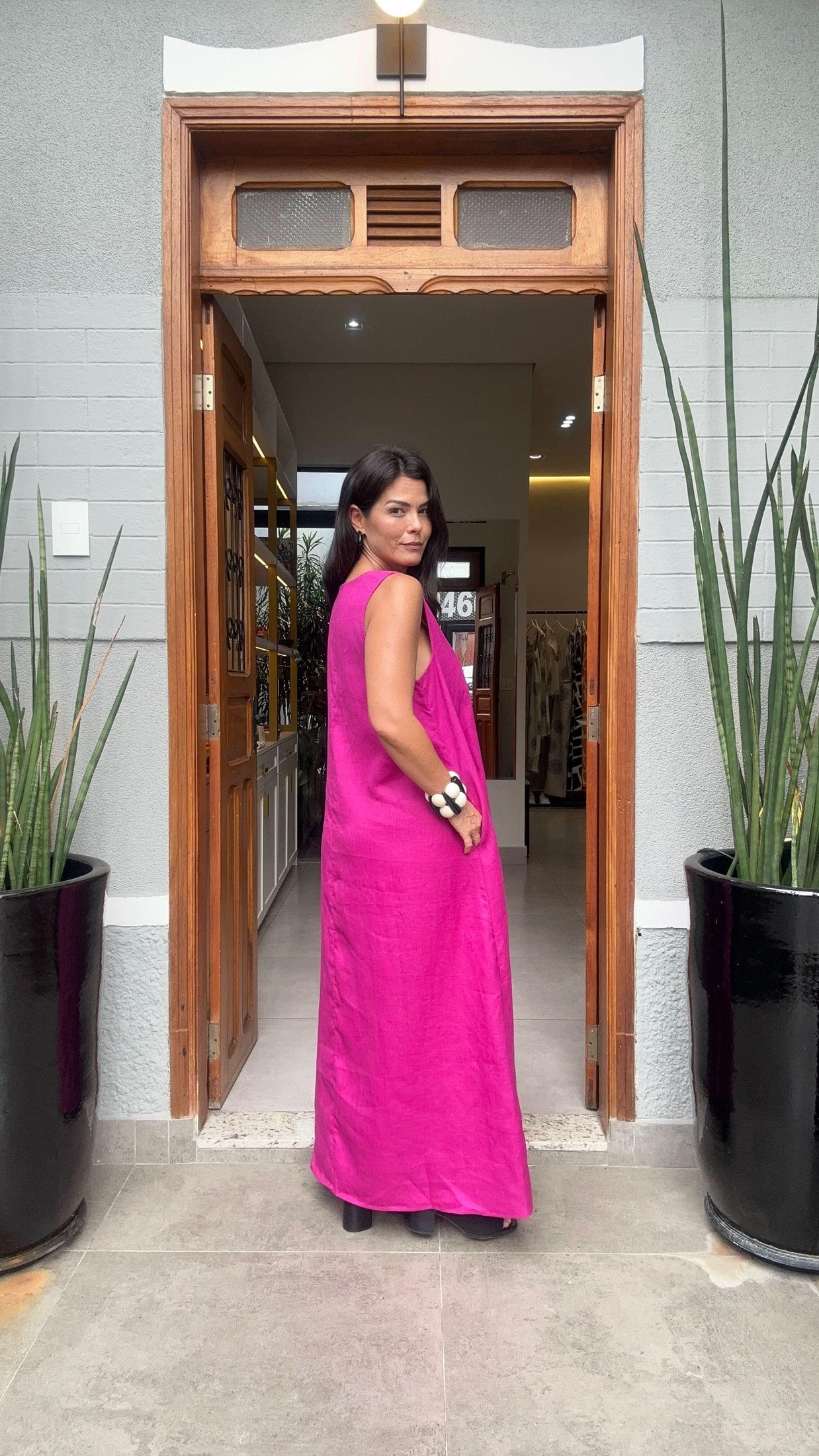 Mulher usando vestido longo de linho rosa em frente à porta, moda feminina elegante EZILDINHA