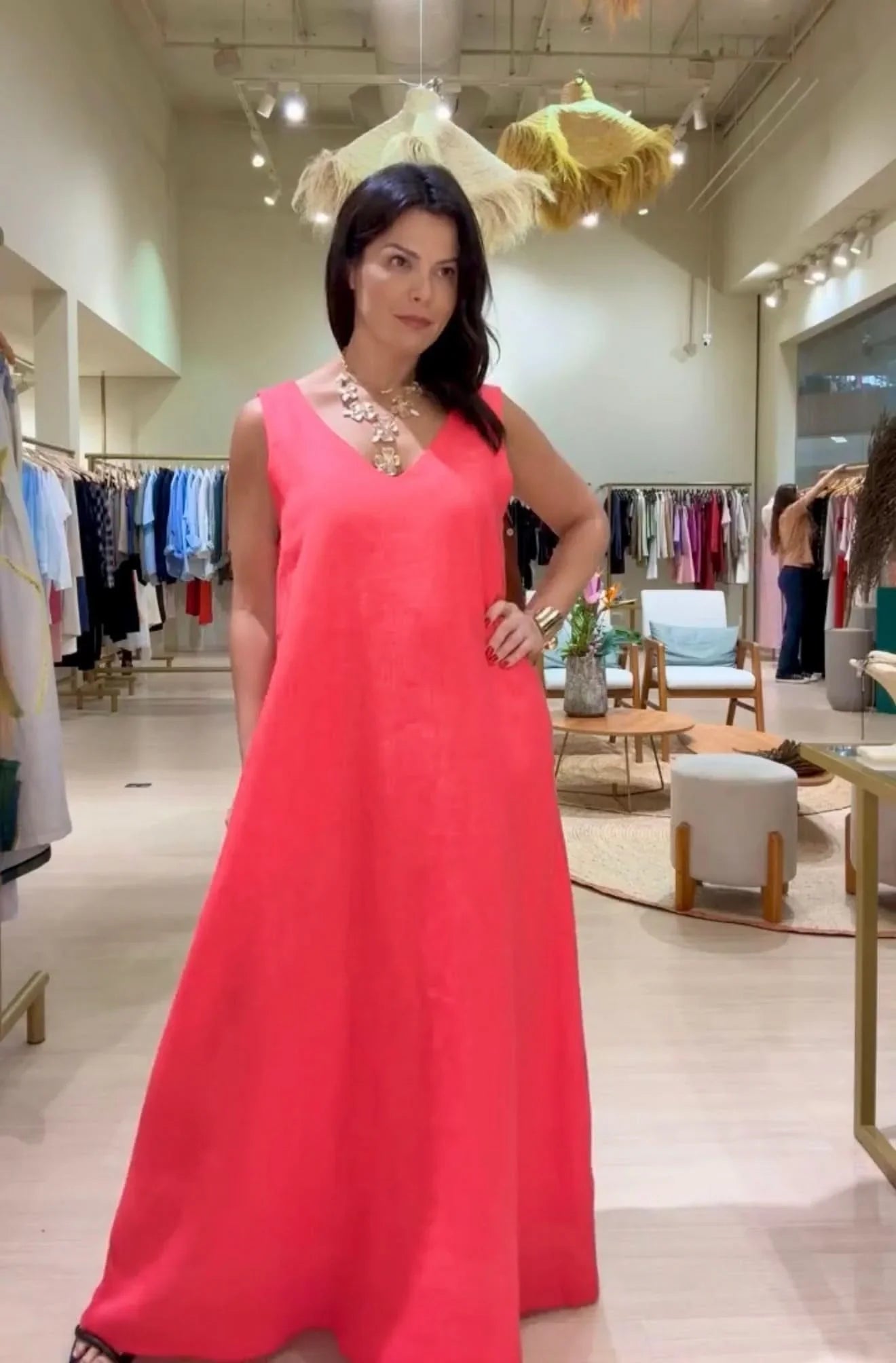 Mulher usando vestido longo de linho rosa, decote V, em loja de roupas sofisticada EZILDINHA