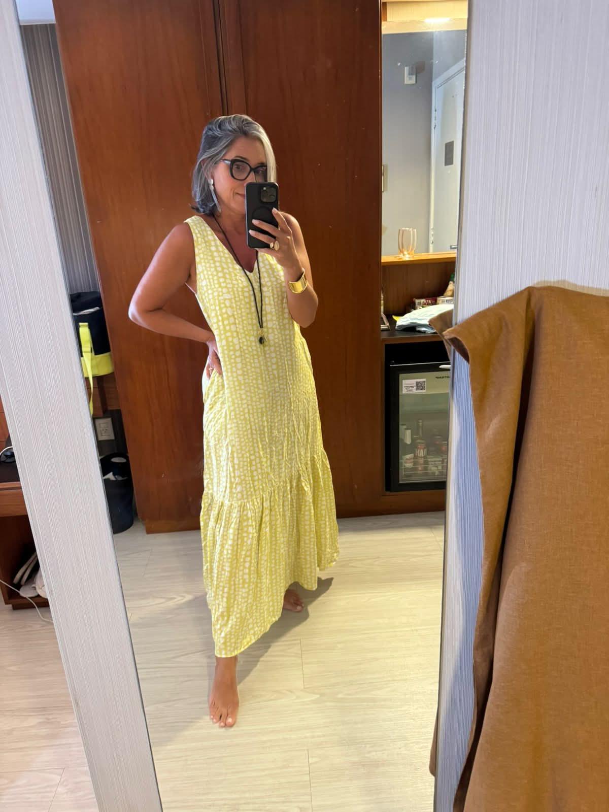 Mulher usando vestido longo amarelo de algodão com padrão geométrico, tirando selfie em espelho EZILDINHA