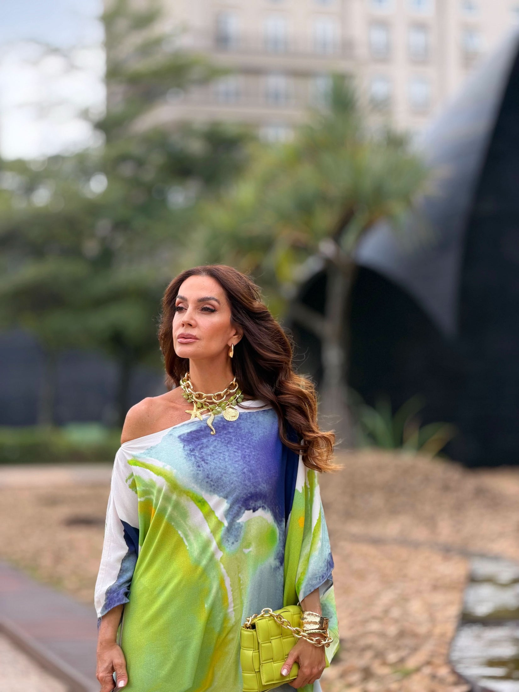 Mulher usando kaftan estampado aquarela em tons de verde, azul e branco ao ar livre EZILDINHA