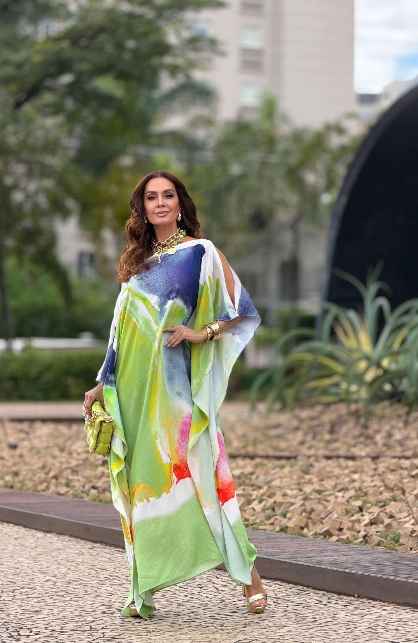 Mulher usando kaftan longo de seda com estampa aquarela colorida ao ar livre EZILDINHA