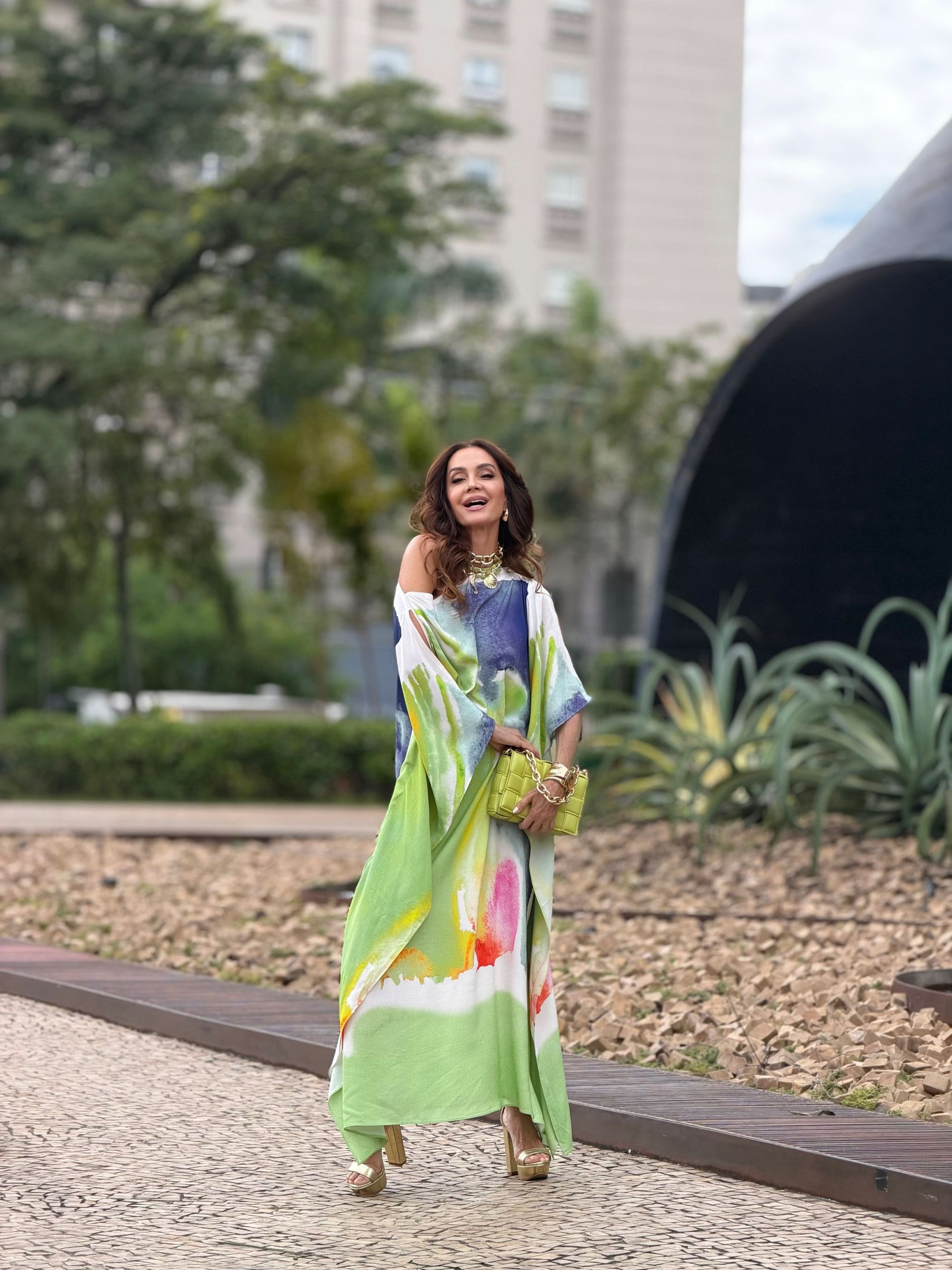 Mulher usando vestido kaftan longo com estampa aquarela colorida ao ar livre EZILDINHA