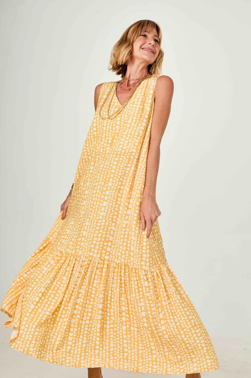Mulher usando vestido longo amarelo estampado sem mangas, tecido leve, caimento fluido EZILDINHA