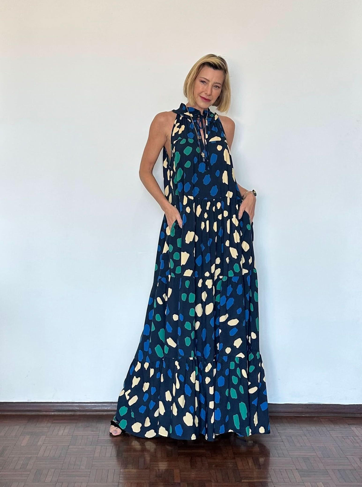 Mulher usando vestido longo azul estampado com alças e detalhe de amarração no pescoço EZILDINHA