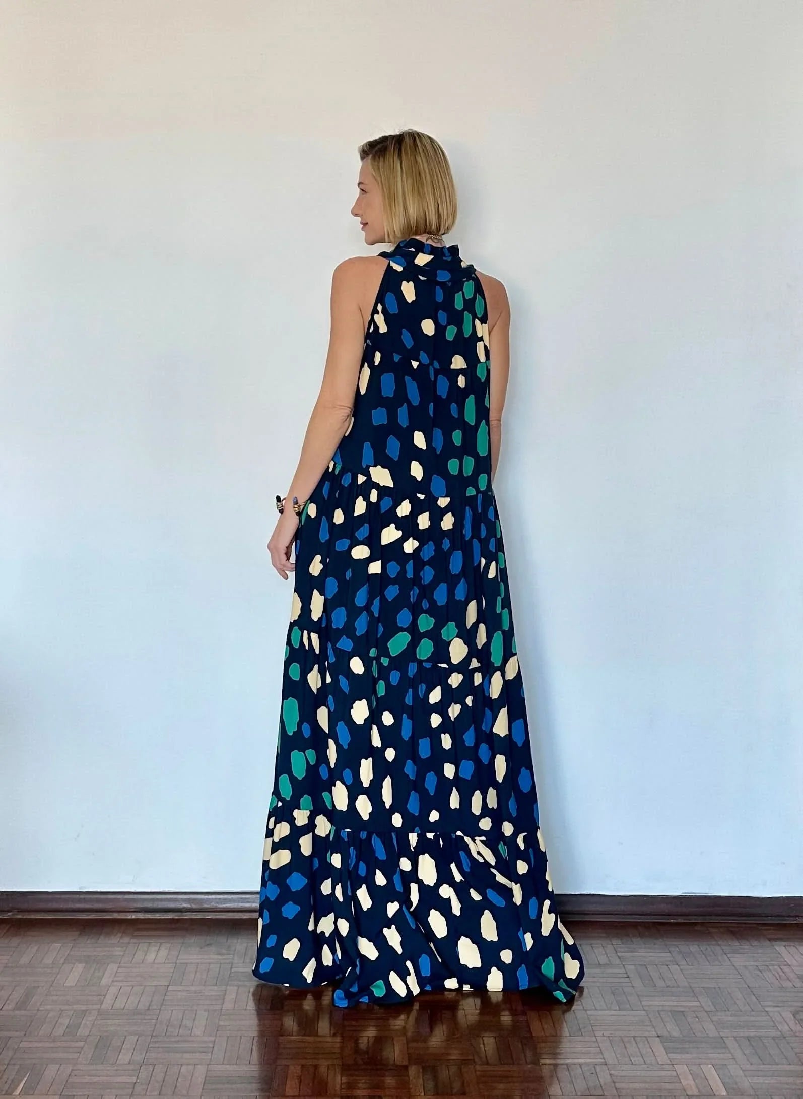 Vestido longo estampado com fundo azul e padrões coloridos, modelagem solta e gola alta EZILDINHA