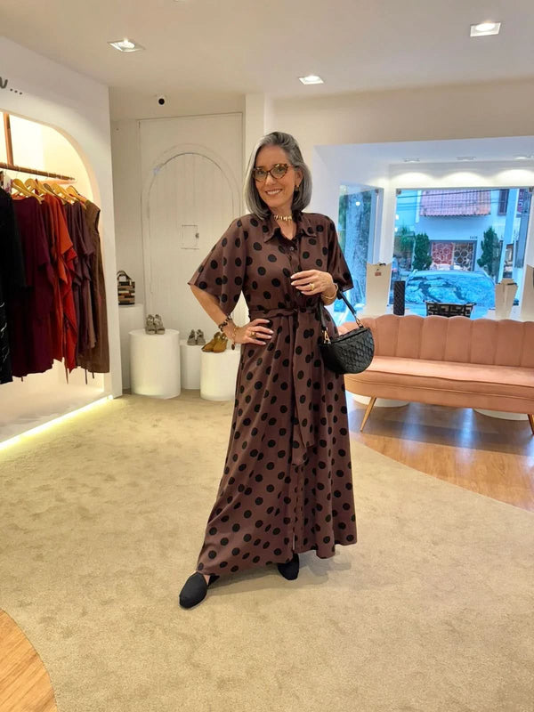 Mulher usando vestido longo marrom de poá preto em loja de moda contemporânea EZILDINHA