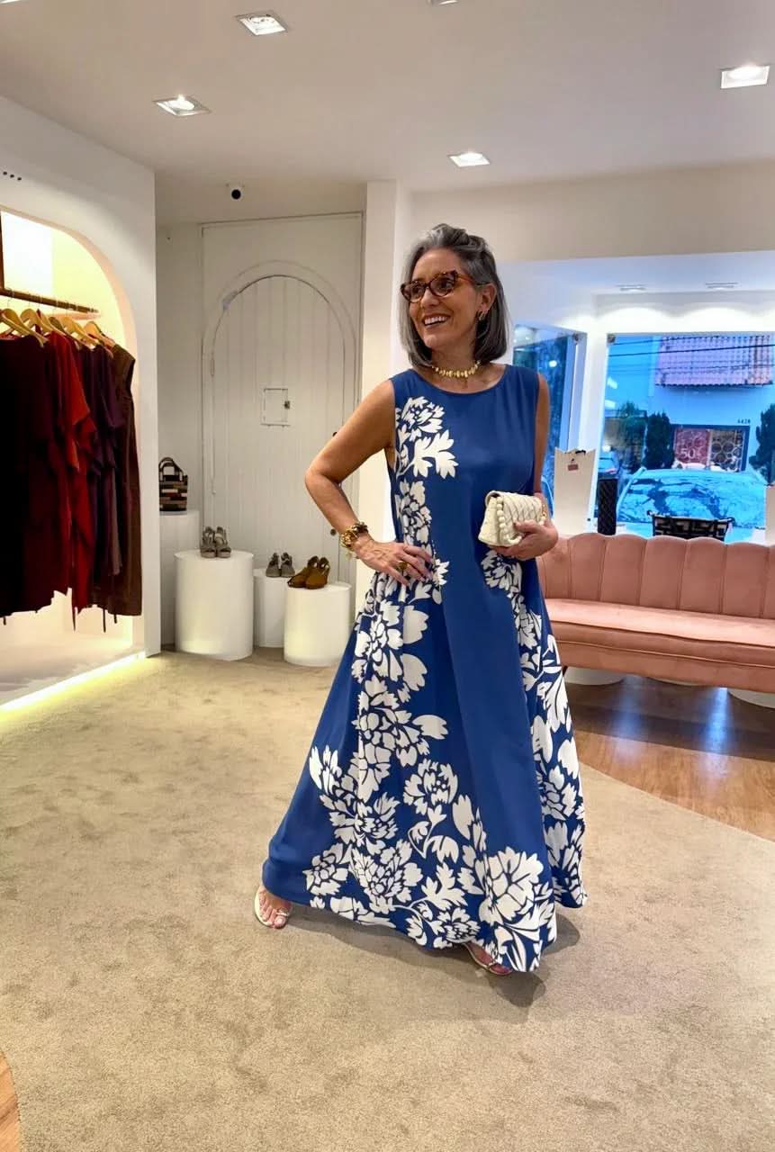 Mulher sorrindo com vestido regata azul estampado de flores brancas em loja elegante EZILDINHA