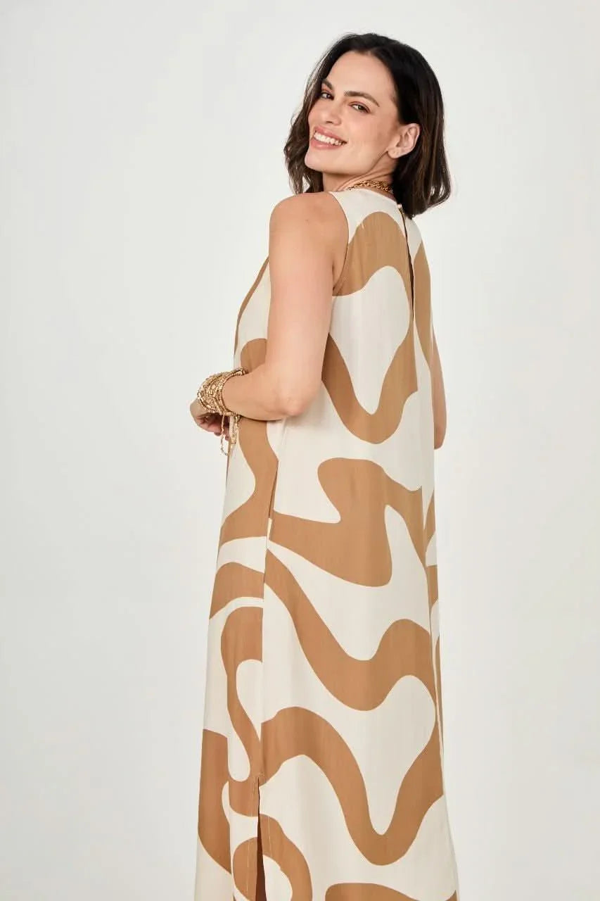 Mulher usando vestido longo bege e branco com estampa de ondas, modelagem ampla e sem mangas EZILDINHA