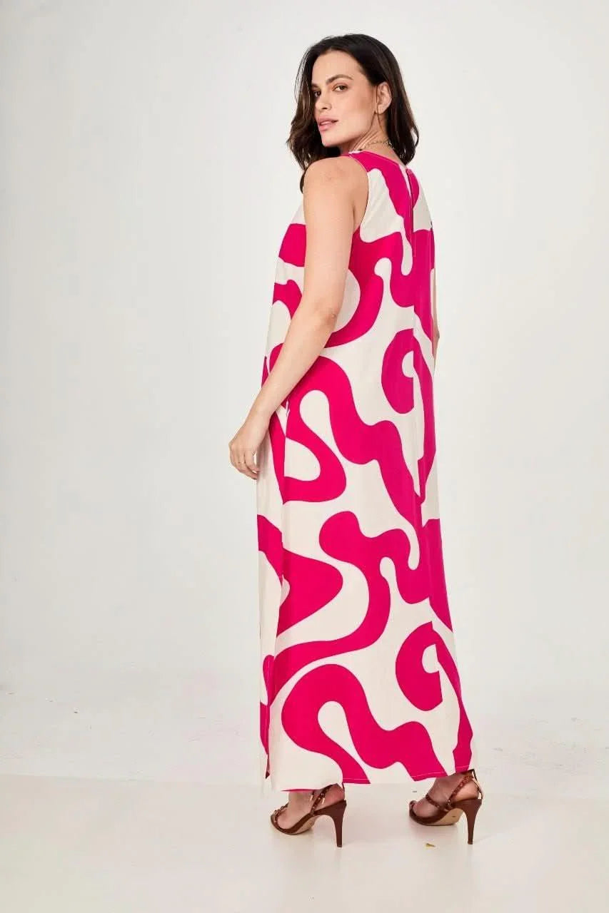 Mulher usando vestido longo bege com estampa waves pink, modelagem ampla e sandálias EZILDINHA